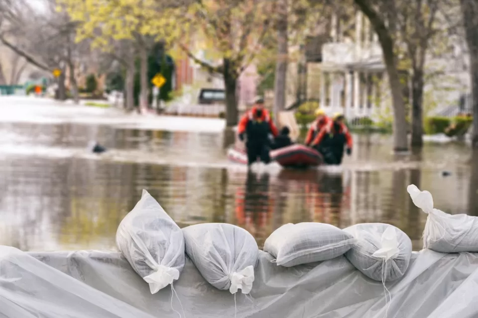 Sandbags in a flood with flooded buildings in background